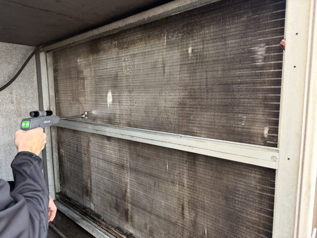 Technician measuring condenser coil temperature